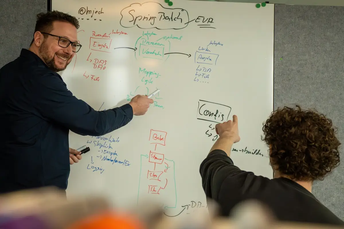 Heiko Schönemann erklärt am Whiteboard ein Spring-Batch-Diagramm