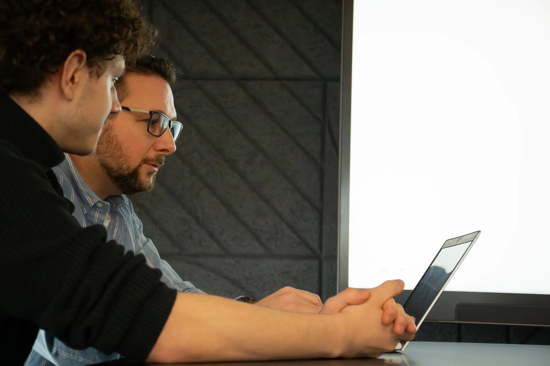 Heiko Schönemann bespricht mit einem Kollegen eine Aufgabe am Laptop